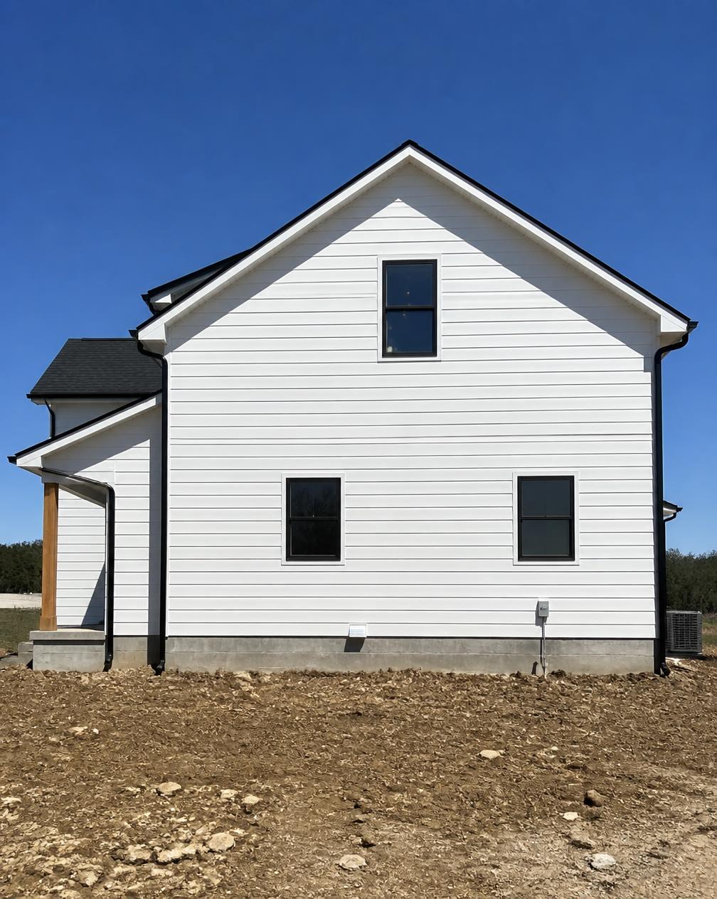 Newly constructed home with freshly painted white siding and black trim by George Harper Painting